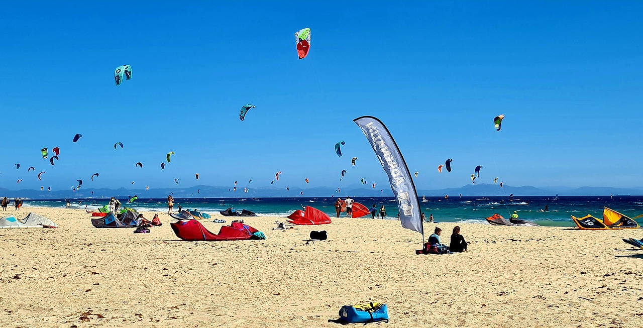 Playa de Los Lances en Tarifa con decenas de cometas de kitesurf sobre el mar y el pueblo al fondo