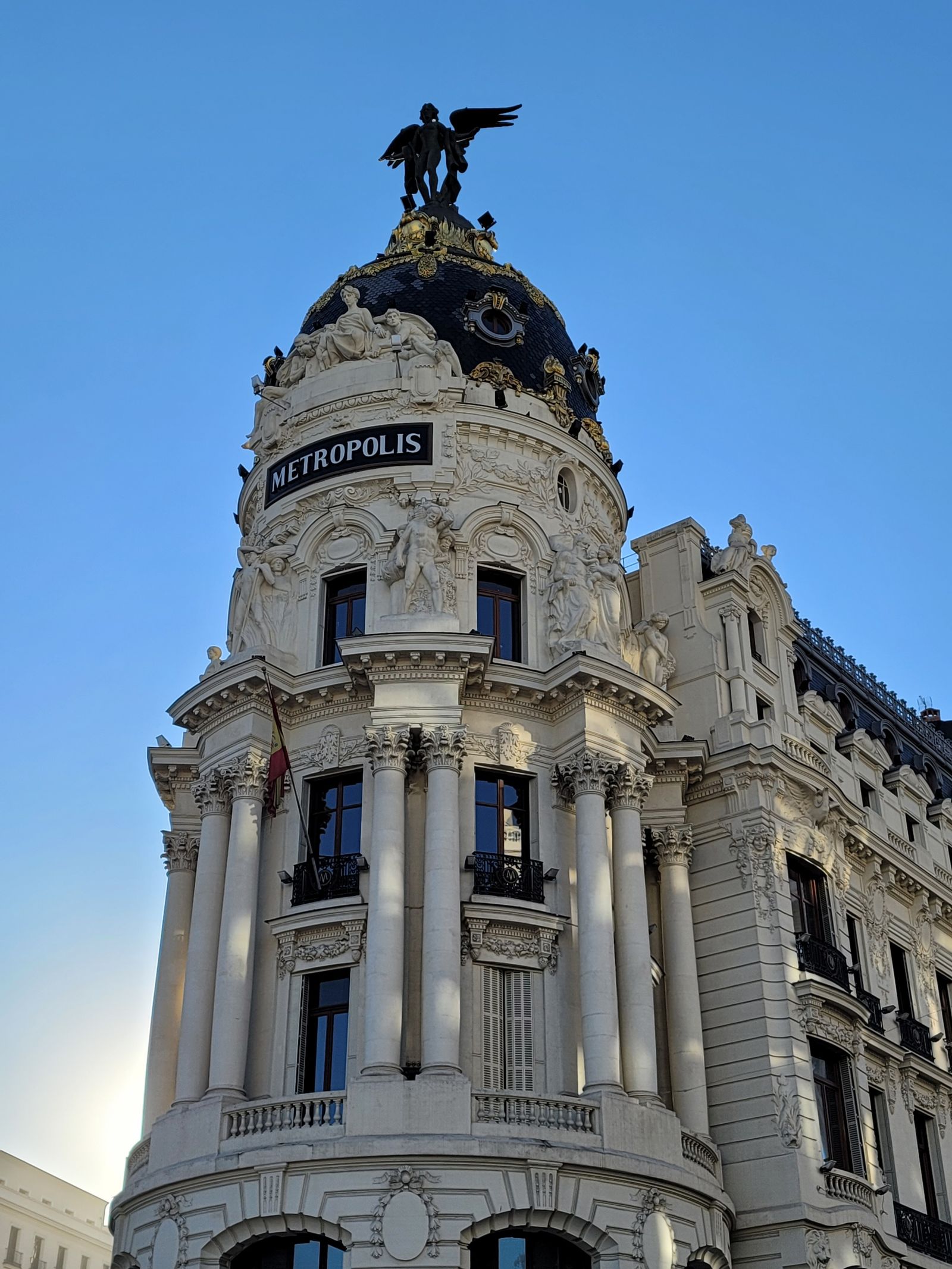 Fachada del Palacio Real de Madrid vista desde la plaza empedrada bajo un cielo azul